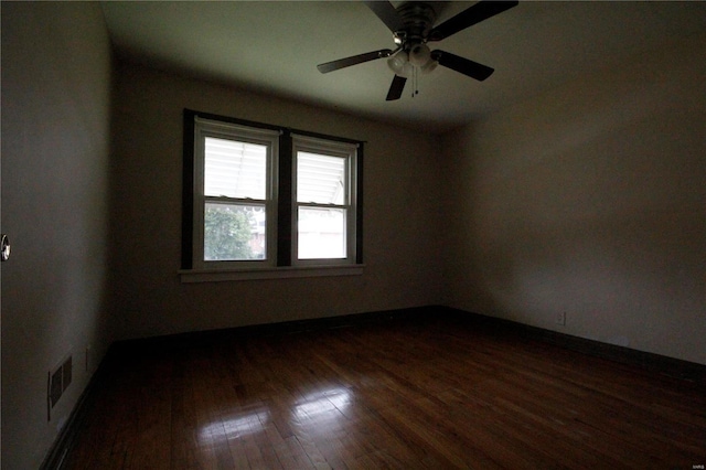 spare room with a ceiling fan, dark wood-style flooring, and visible vents