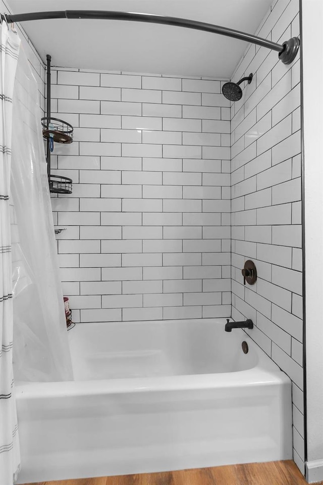 bathroom with wood-type flooring and shower / bathtub combination with curtain