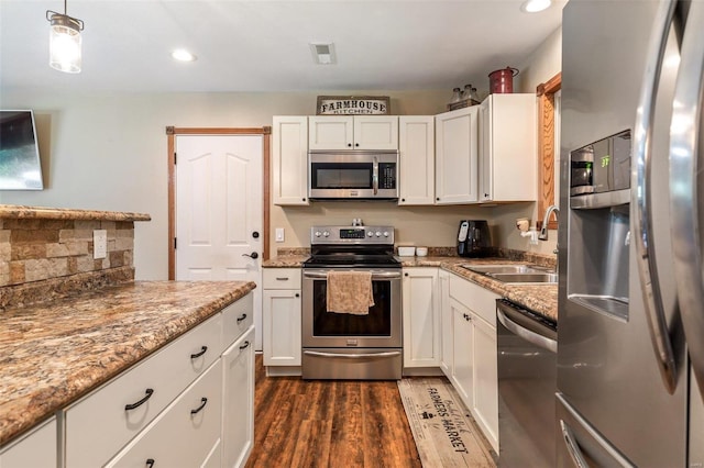 kitchen with dark wood-type flooring, stainless steel appliances, sink, and white cabinetry