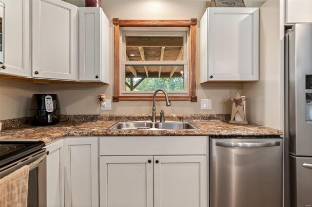 kitchen featuring stainless steel appliances, white cabinetry, and sink