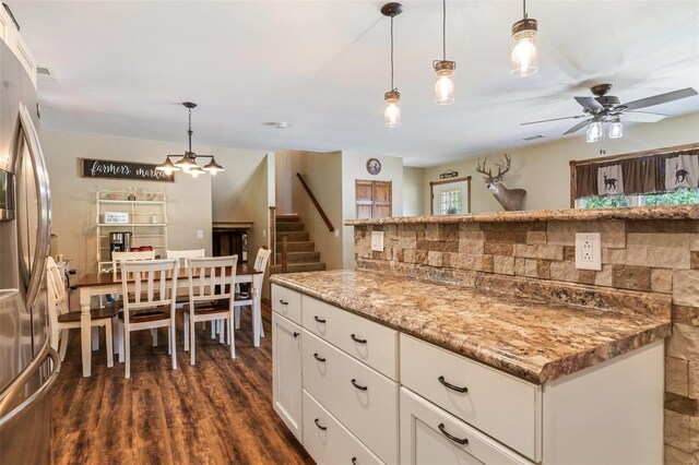 kitchen with stainless steel fridge, white cabinetry, backsplash, ceiling fan, and dark wood-type flooring