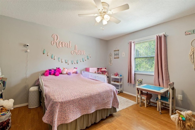 bedroom with ceiling fan, a textured ceiling, and light hardwood / wood-style flooring