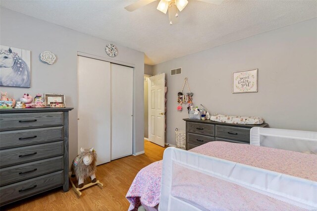 bedroom featuring a textured ceiling, light hardwood / wood-style flooring, and ceiling fan