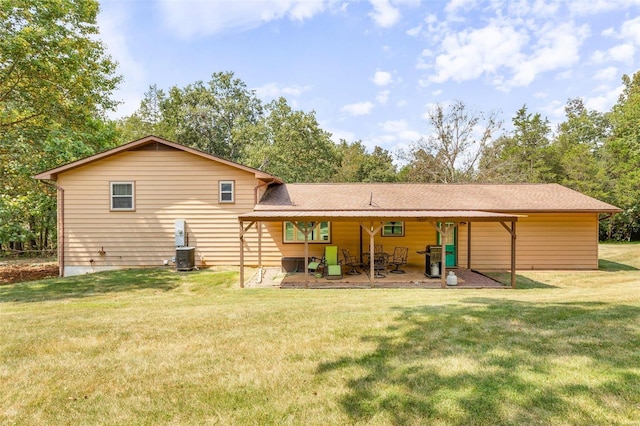 rear view of house with a yard, a patio area, and roof with shingles