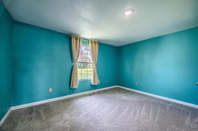 carpeted spare room featuring a textured ceiling