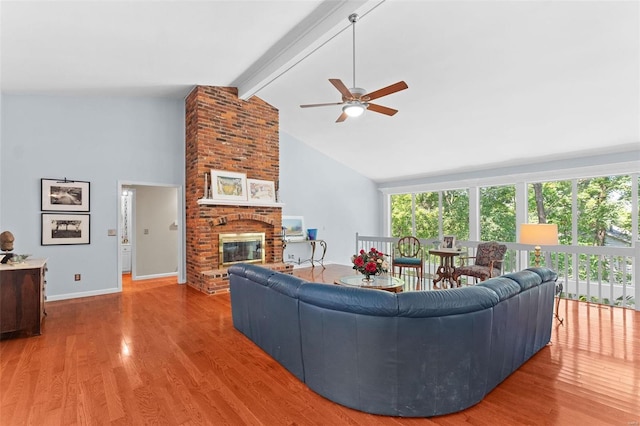 living room featuring high vaulted ceiling, a brick fireplace, ceiling fan, beamed ceiling, and wood-type flooring