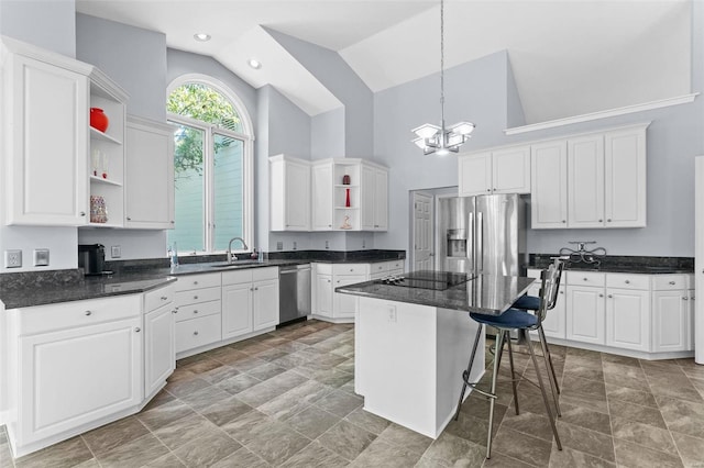 kitchen with sink, a center island, a kitchen breakfast bar, white cabinets, and appliances with stainless steel finishes