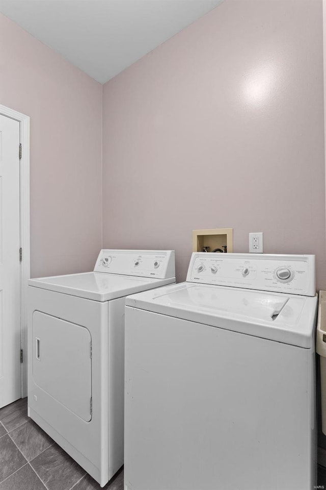 clothes washing area with washer and dryer and dark tile patterned flooring