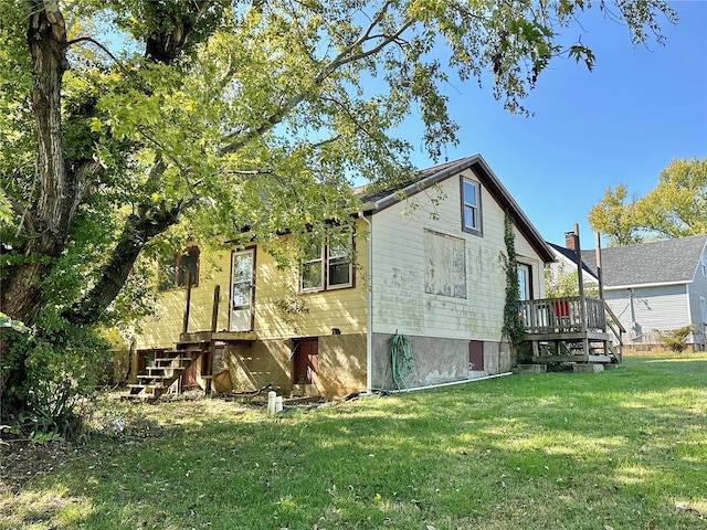 rear view of property featuring a lawn