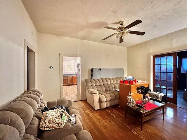 living room featuring ceiling fan, a textured ceiling, and hardwood / wood-style floors