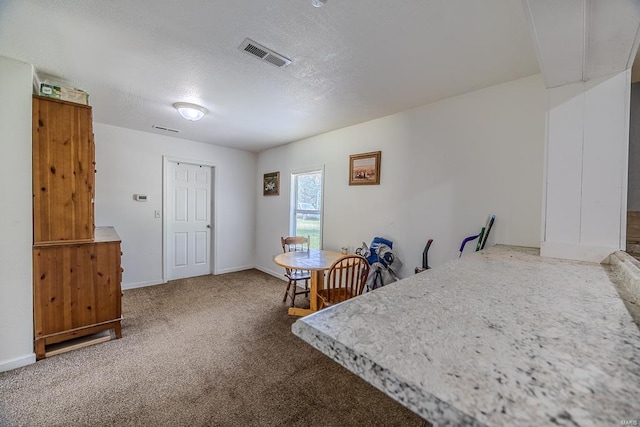 dining space featuring a textured ceiling and carpet