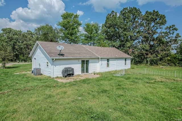 rear view of house with a yard and central air condition unit