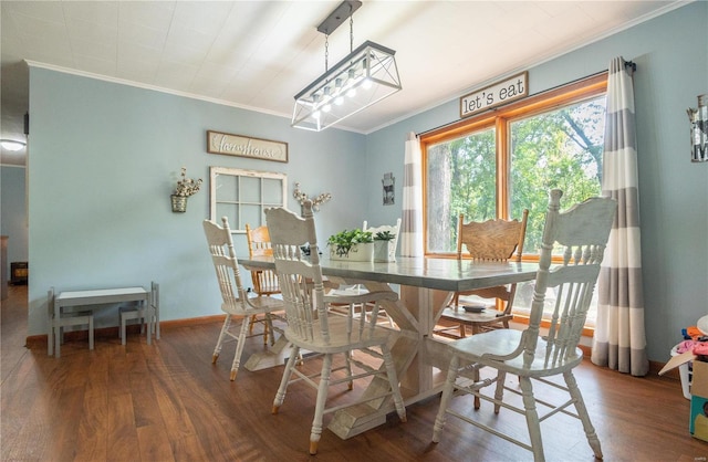 dining area with ornamental molding, wood finished floors, and baseboards