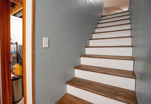 stairway featuring hardwood / wood-style floors and wood walls