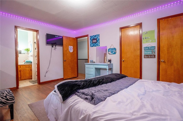 bedroom featuring hardwood / wood-style flooring and ensuite bathroom