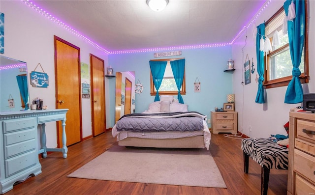 bedroom with multiple windows and wood finished floors