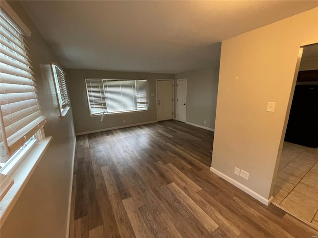 empty room with baseboards and wood finished floors