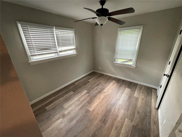 spare room featuring a wealth of natural light, hardwood / wood-style floors, and ceiling fan