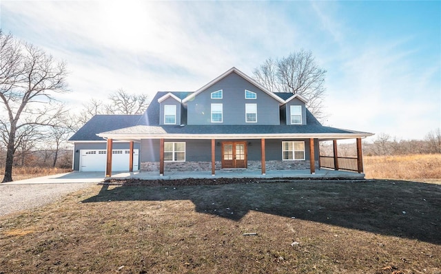 farmhouse inspired home with a porch, a garage, and a front yard