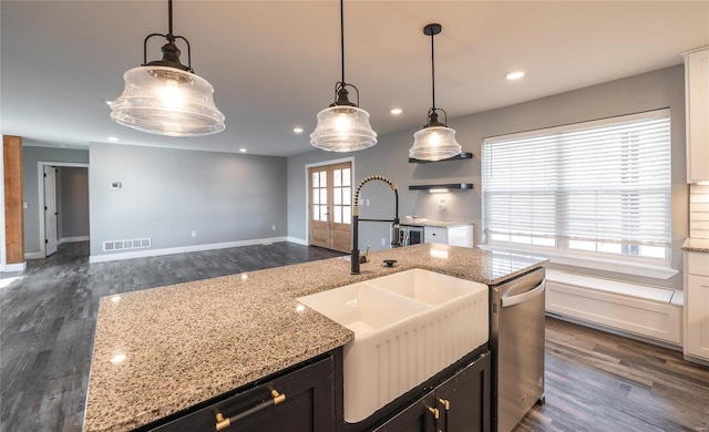 kitchen with hanging light fixtures, dishwasher, sink, and light stone counters