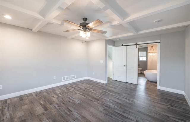 unfurnished bedroom with connected bathroom, beamed ceiling, dark hardwood / wood-style flooring, coffered ceiling, and a barn door