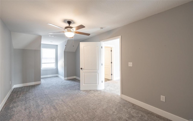 additional living space with vaulted ceiling, carpet flooring, and ceiling fan