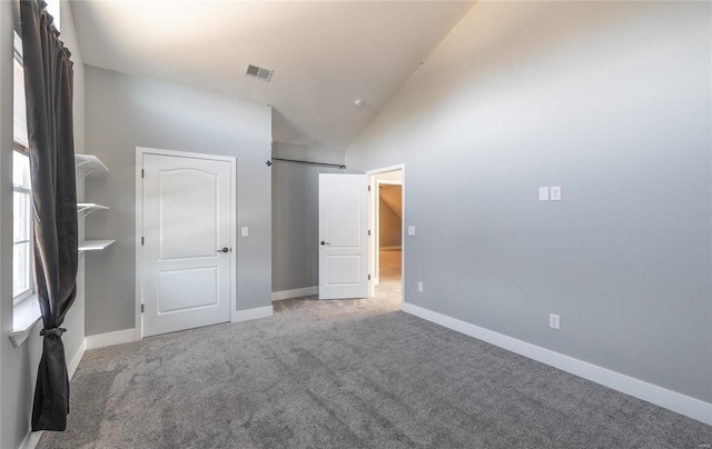 unfurnished bedroom featuring carpet floors and high vaulted ceiling