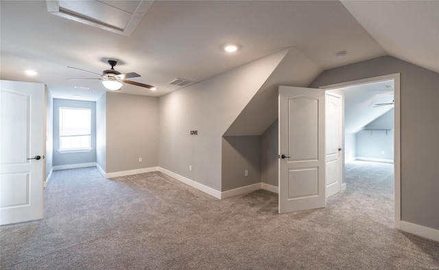 bonus room with lofted ceiling and light colored carpet