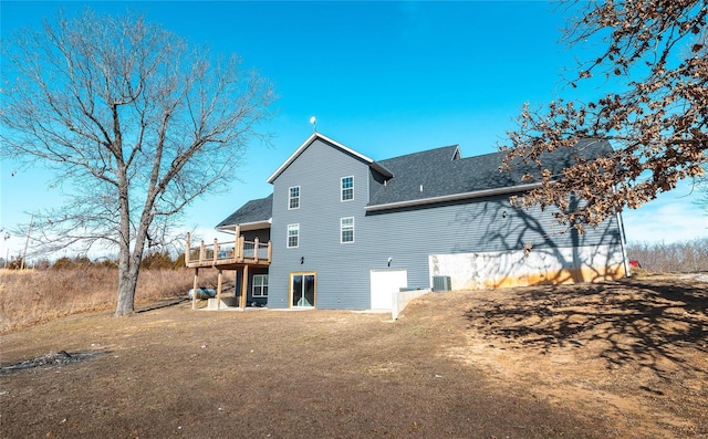 back of property with a yard, cooling unit, and a deck