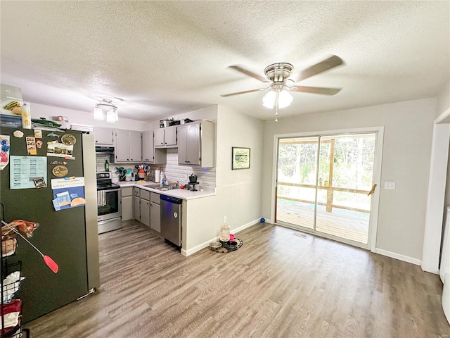 kitchen featuring backsplash, stainless steel appliances, light hardwood / wood-style floors, sink, and gray cabinets