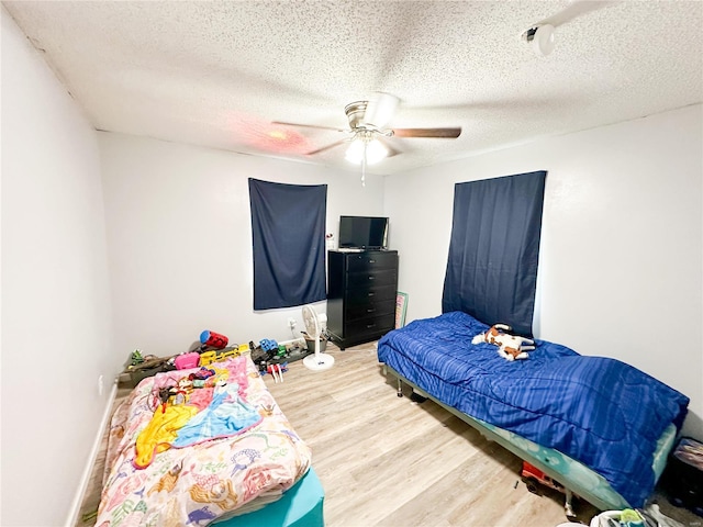 bedroom featuring ceiling fan, a textured ceiling, and light hardwood / wood-style flooring