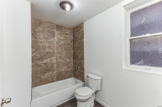 bathroom with tiled shower / bath combo, toilet, and hardwood / wood-style floors