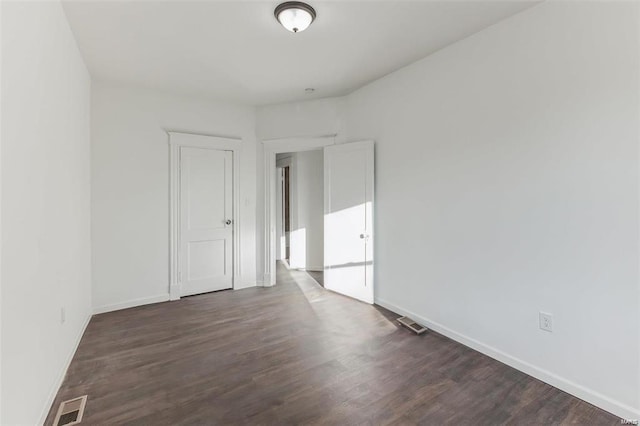 unfurnished room with dark wood-type flooring