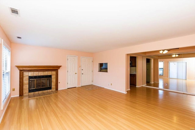 unfurnished living room featuring ceiling fan, hardwood / wood-style flooring, and a fireplace