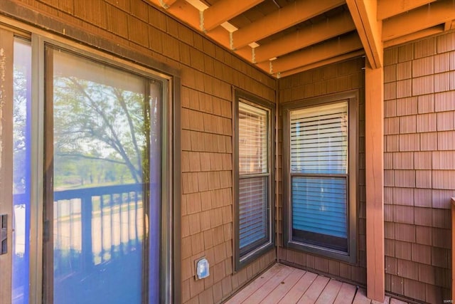 exterior space with beam ceiling and light hardwood / wood-style floors