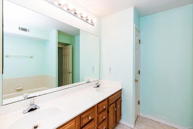 bathroom featuring vanity, tile patterned floors, and a washtub