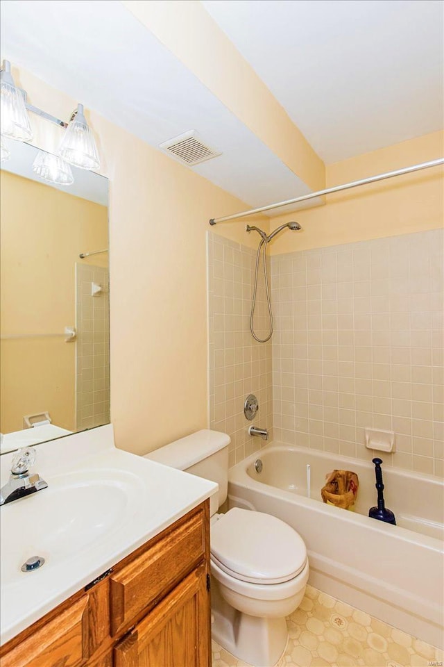 full bathroom featuring vanity, toilet, tiled shower / bath combo, and tile patterned floors