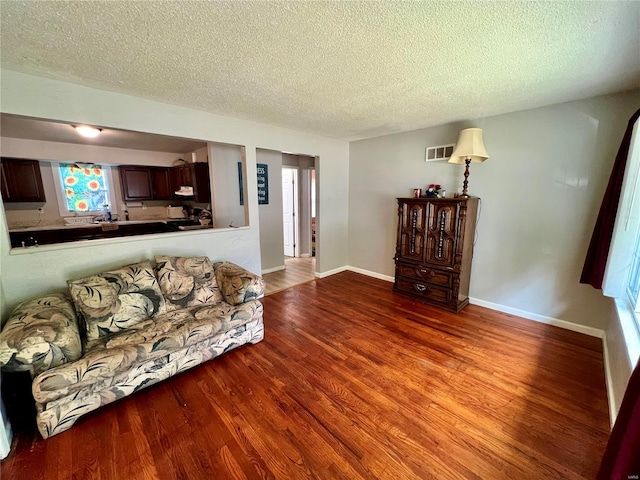 living room with wood-type flooring and a textured ceiling