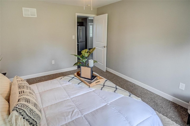 carpeted bedroom with stainless steel refrigerator