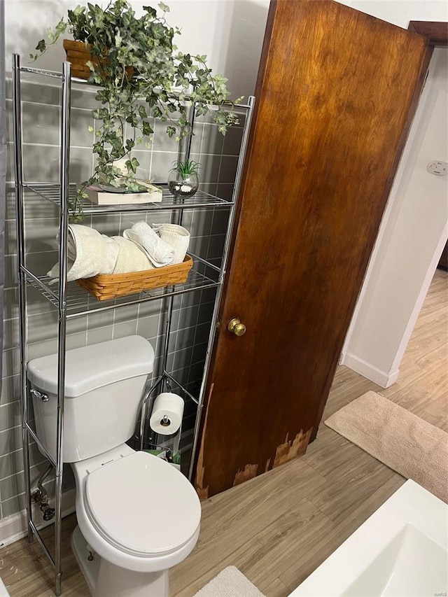 bathroom featuring wood-type flooring and toilet