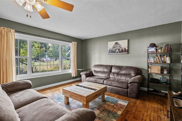 living room featuring a textured ceiling, ceiling fan, and dark hardwood / wood-style flooring