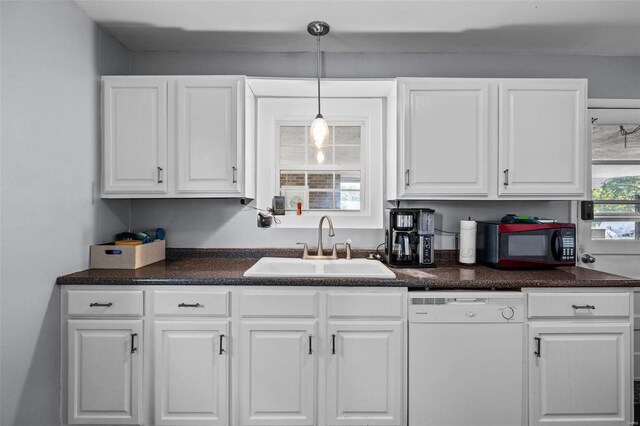 kitchen with white dishwasher, hanging light fixtures, sink, and white cabinets