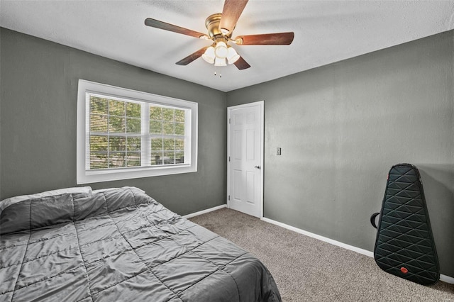 bedroom with ceiling fan, carpet, and a textured ceiling