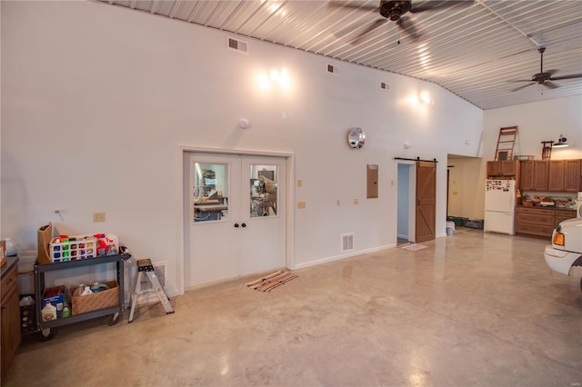 garage featuring white refrigerator, ceiling fan, and electric panel