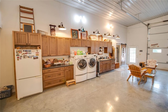 laundry area featuring sink, washer and clothes dryer, and a towering ceiling