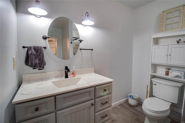 bathroom with vanity, toilet, and hardwood / wood-style flooring