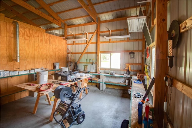 garage featuring wooden walls, wooden ceiling, and a workshop area