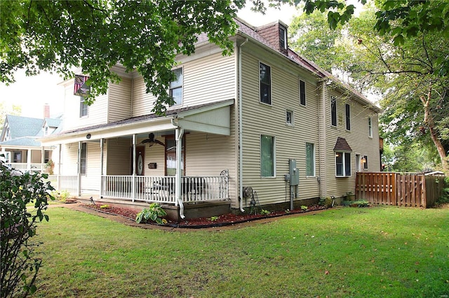 view of front of property with a porch, a front lawn, and fence