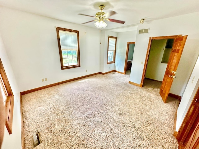 unfurnished bedroom featuring a ceiling fan, visible vents, light carpet, and baseboards