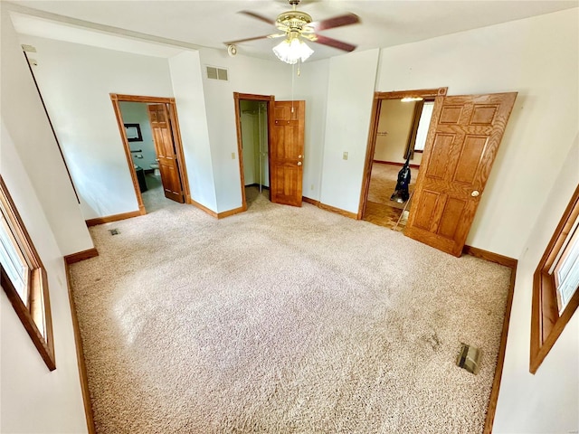 unfurnished bedroom featuring a ceiling fan, carpet, visible vents, and baseboards